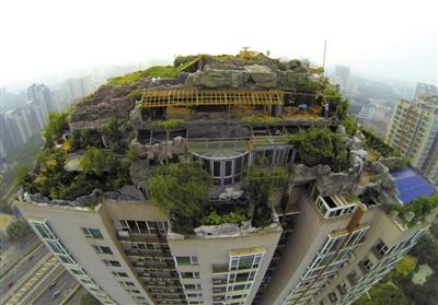 　　昨日，身穿橘黃色馬甲的工作人員在人濟山莊樓頂拆除違章建筑。新京報記者 吳江 攝