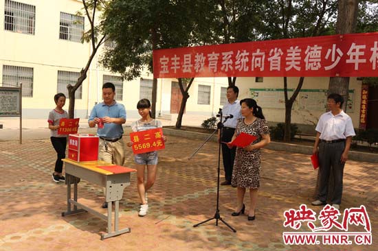 寶豐縣教育系統(tǒng)全體人員在石橋鎮(zhèn)中學為“美德少年”楊冠明同學捐款。