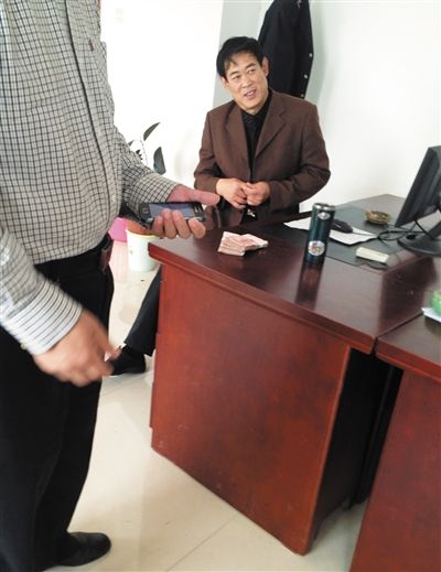 10月29日，獻(xiàn)縣國(guó)稅局稽查局辦公室內(nèi)，一名企業(yè)主交了兩萬(wàn)元現(xiàn)金在桌上。新京報(bào)記者 孟祥超 攝
