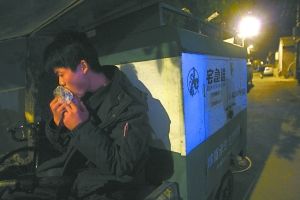 快遞哥抽空吃兩口東西。記者 李剛 攝