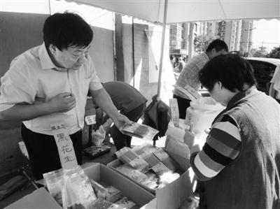 昨日，河南企業(yè)家劉春喜在京“練攤”，為顧客挑選綠豆。新京報(bào)記者 張玉學(xué) 攝