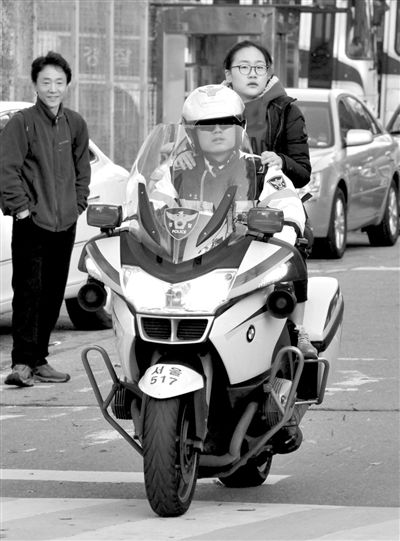 7日，首爾，警察將一名考生送抵考場。新華社發(fā)