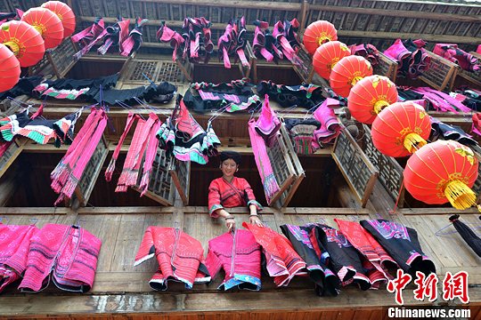 圖為紅瑤姑娘把紅衣晾曬出來。中新社發(fā) 韋吉陽 攝