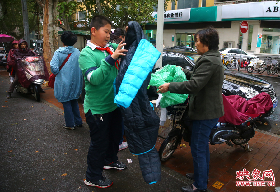 學(xué)校門口，家長給孩子帶來了御寒的厚衣服。