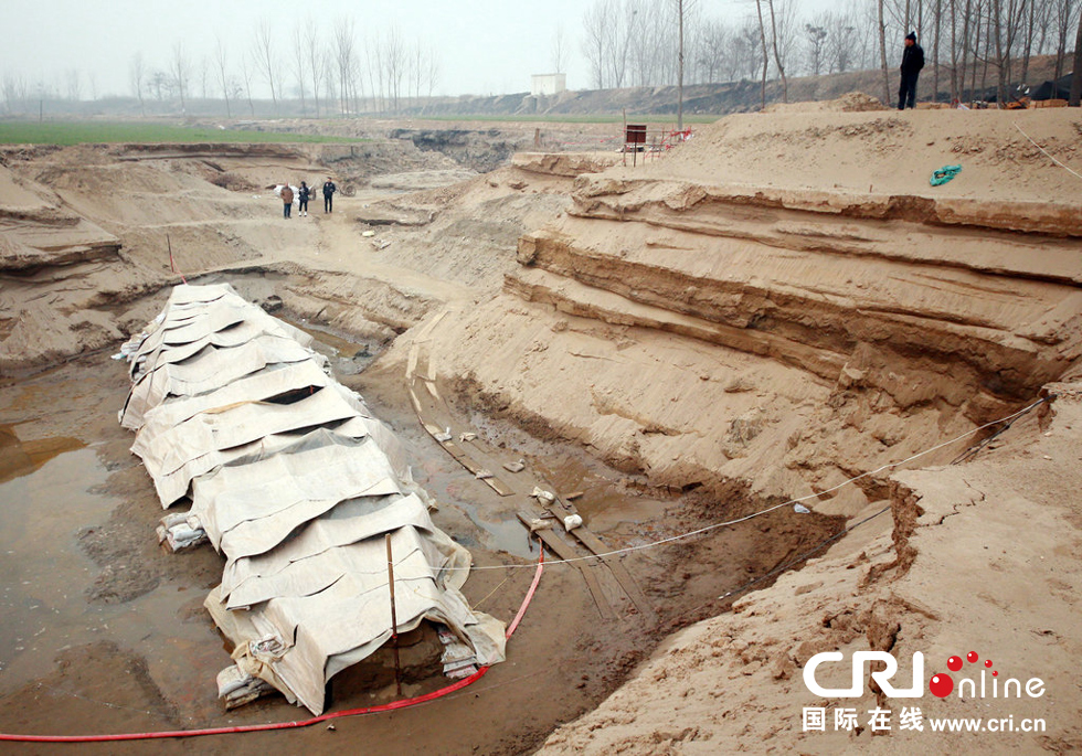 2014年1月6日，河南洛陽古沉船發(fā)掘現(xiàn)場，近日有雨雪天，考古人員給古沉船披上一層“雨衣”。
