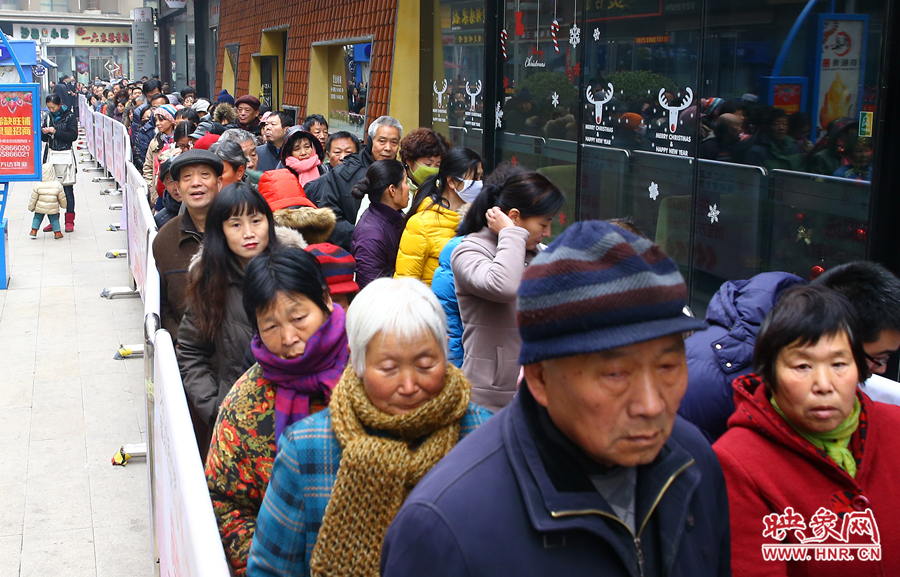 領(lǐng)粥的市民排起了長隊，足有上千人。