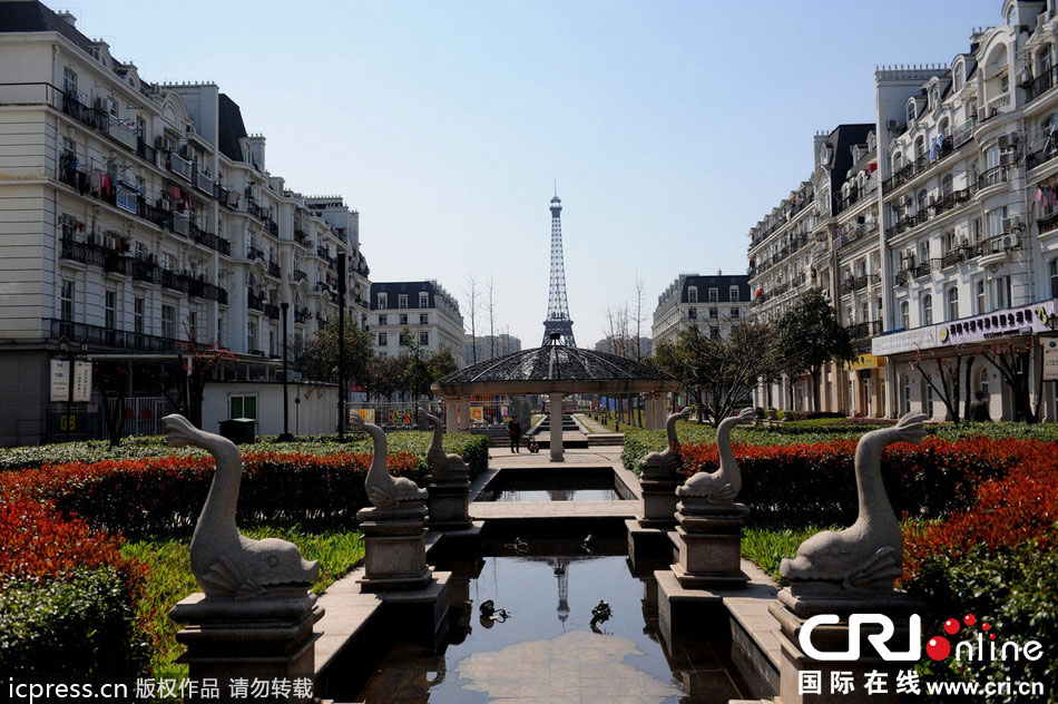 　2014年3月21日，杭州天都城，農(nóng)民在山寨埃菲爾鐵塔下耕作。圖片來(lái)源：東方IC