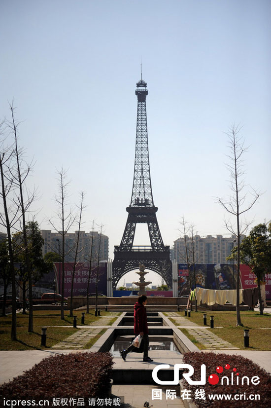 　2014年3月21日，杭州天都城，農(nóng)民在山寨埃菲爾鐵塔下耕作。圖片來(lái)源：東方IC