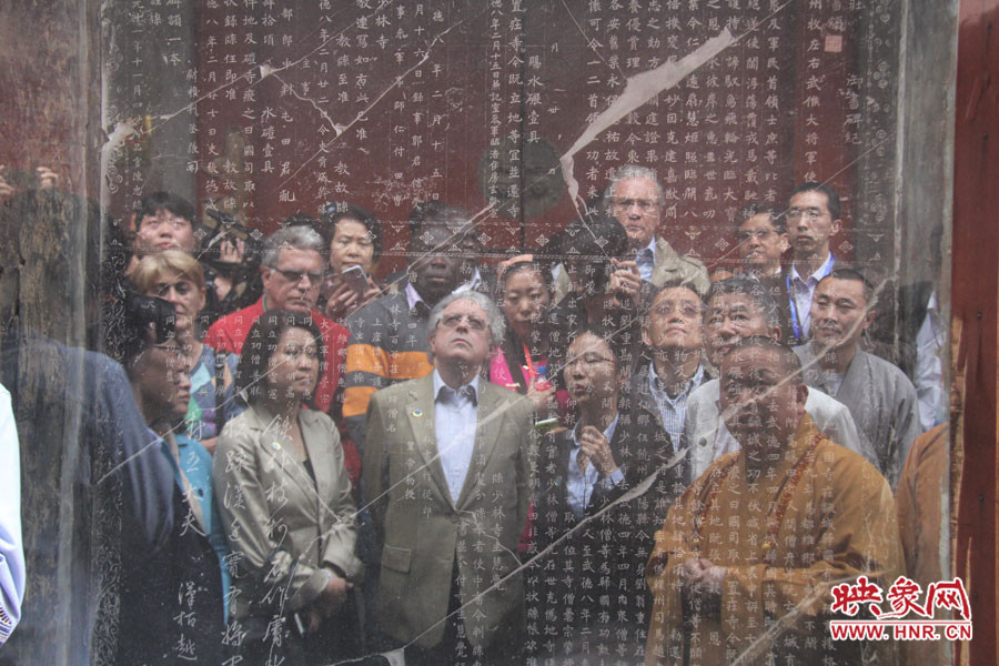 在一塊石碑前，少林寺方丈正在講解
