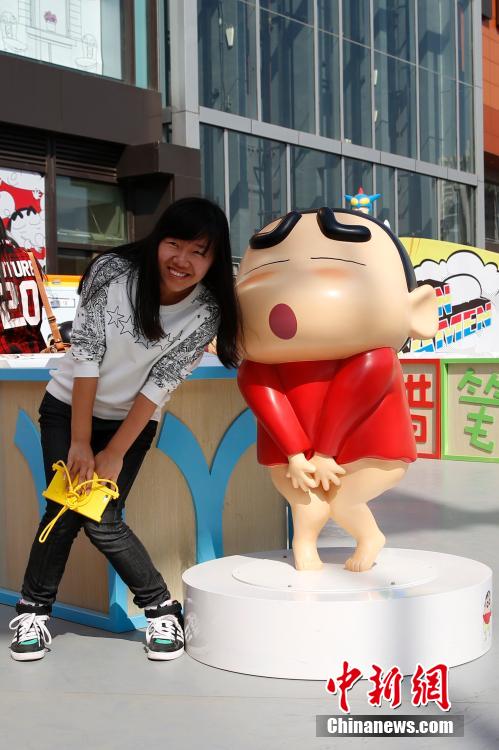4月22日，游客與蠟筆小新合影?！跋灩P小新25周年紀(jì)念特展”日前在北京開展，吸引了不少市民游客。