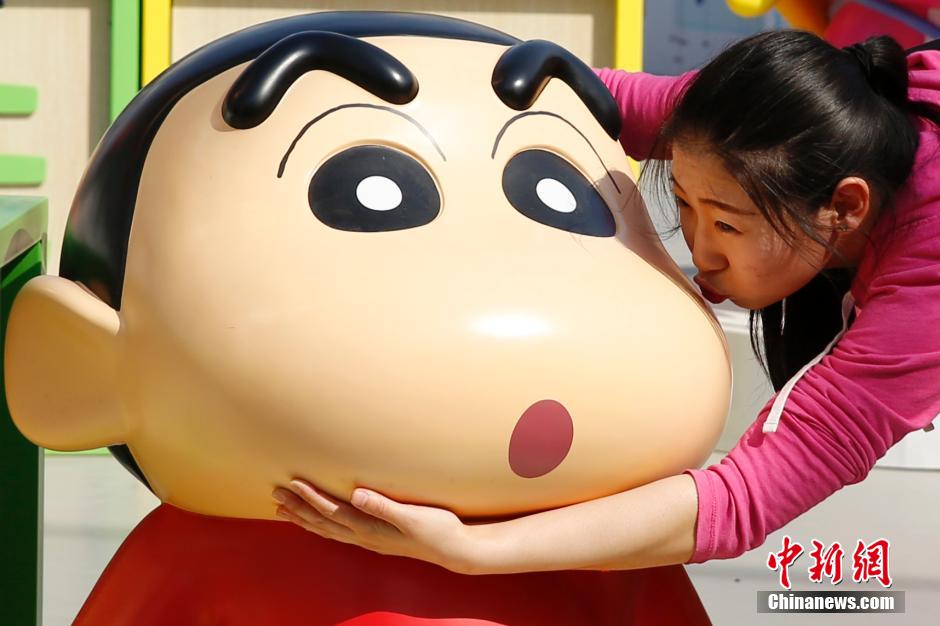 4月22日，游客與蠟筆小新合影?！跋灩P小新25周年紀(jì)念特展”日前在北京開展，吸引了不少市民游客。