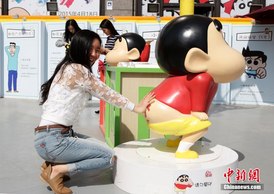 4月22日，游客與蠟筆小新合影。“蠟筆小新25周年紀(jì)念特展”日前在北京開展，吸引了不少市民游客。