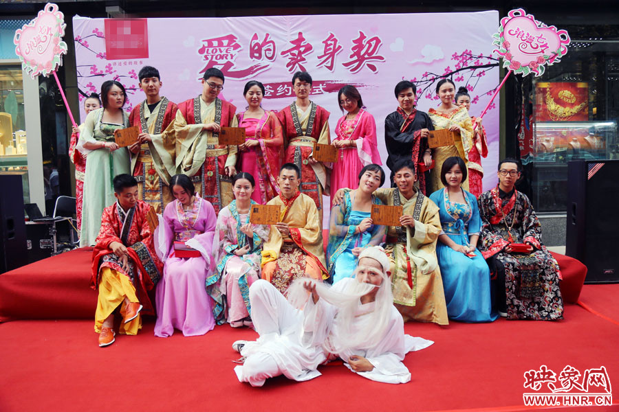 現(xiàn)場8對兒年輕男女舉起“賣身契”集體拍照。