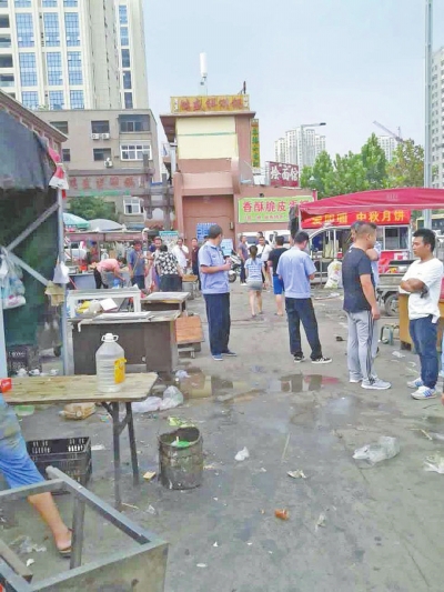昨天，執(zhí)法人員在京廣路長(zhǎng)江路口整治“僵尸圍擋”及圍擋內(nèi)的攤販。