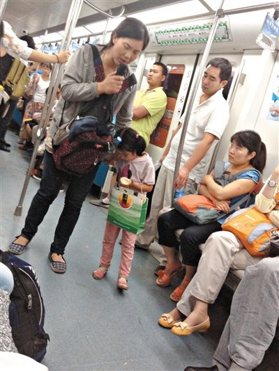 6月27日，舒馨帶一女孩在地鐵十號(hào)線行乞。她因被疑帶多個(gè)不同小孩乞討被警方搜尋。新京報(bào)記者 申志民 攝