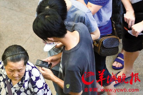 排隊的“黃?！备魇謭?zhí)一疊白紙，上面寫好了要掛號的人的信息，包括姓名、電話、要掛的科室等。穿黑白花紋衣服的老婆婆正在排隊掛號
