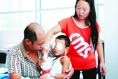 斌斌手術(shù)后第一天恢復(fù)良好，斌斌父母在用玩具逗他開心供圖/嚴(yán)益