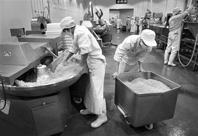 昨日，位于順義李遂開發(fā)區(qū)的慶豐包子鋪配送中心生產(chǎn)車間，工人們正在斬拌胡蘿卜餡料。