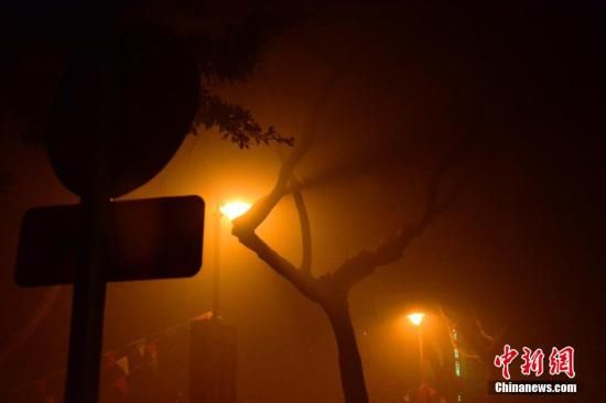 1月31日凌晨，市民行走在煙霧繚繞的南京街頭。當(dāng)天是農(nóng)歷馬年正月初一，南京有限開禁燃放煙花爆竹正逢下霧天，空氣的不流通致使煙花爆竹燃燒后產(chǎn)生的顆粒物不能及時散開，造成整座城市煙霧繚繞。據(jù)當(dāng)?shù)丨h(huán)保部門發(fā)布的信息顯示，空氣質(zhì)量屬重度污染。中新社發(fā) 泱波 攝