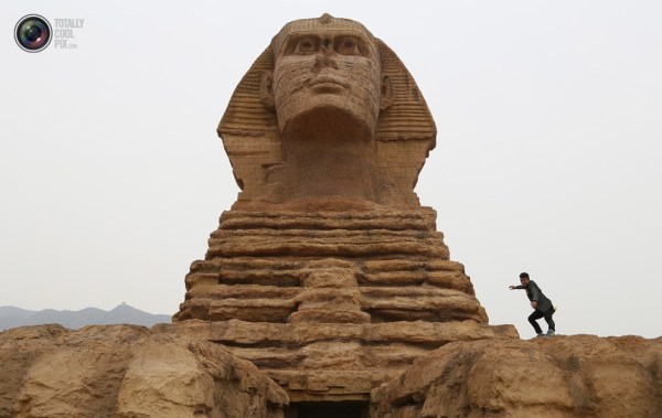 石家莊郊外，一名男子與山寨版獅身人面像合影留念。
