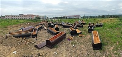 40多副棺木被砸壞后，扔在荒地上。