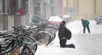 小伙子跪在樓前，一直抬頭看著樓上。 孫立國/攝