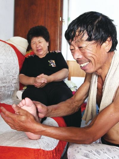 慈成富為老伴按摩。