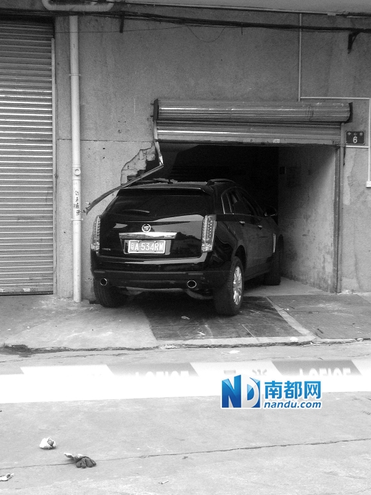 　昨日，凱迪拉克撞人后停在一倉(cāng)庫(kù)門口，車后有一攤血跡。 南都記者陳杰生攝