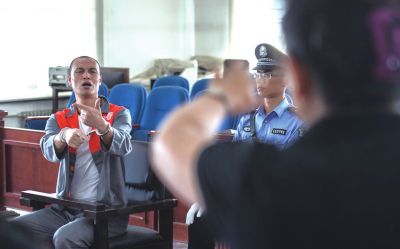 張志國(guó)在法庭上用手語(yǔ)回答提問。記者 蒲東峰攝