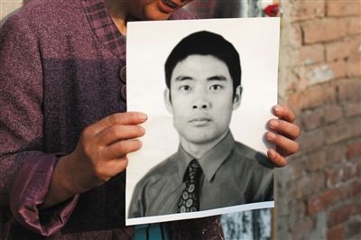 5月19日，朝陽北路，母親捧著張東文的遺像。新京報記者 侯少卿 攝