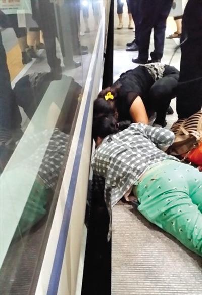 一女子趴在站臺(tái)上，救跌入列車和站臺(tái)間隙的男童。網(wǎng)友璀璨的星月夜 攝