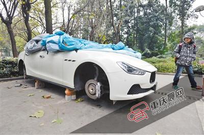 昨日，停放在重慶大學(xué)B區(qū)的一輛瑪莎拉蒂豪車被架在幾塊磚頭上，車輪不翼而飛。 重慶晨報(bào)記者 胡杰 攝