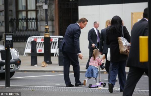 英國(guó)首相卡梅倫步行送女兒上幼兒園。