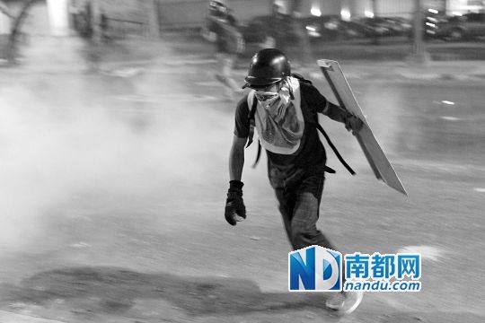 反政府示威者在與警察的沖突中躲避催淚彈。