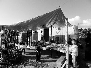 黎巴嫩一敘利亞難民營，難民支起攤鋪賣衣服掙錢。