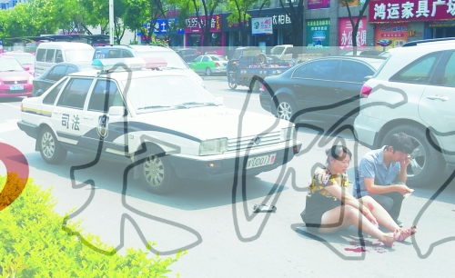 事故發(fā)生后，警車司機(jī)（右）下車查看傷者并撥打120，倆“領(lǐng)導(dǎo)”穩(wěn)坐車內(nèi)引發(fā)圍觀者不滿。