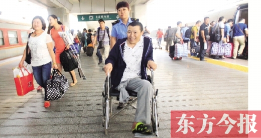 李剛手術(shù)后歸來，在車站工作人員幫助下走出鄭州火車站站臺  東方今報首席記者 張曉冬 攝