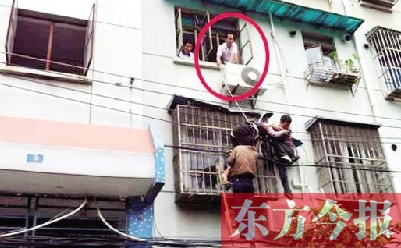 施救現(xiàn)場，劉鵬（圈內(nèi)）先用繩子捆住老太確保安全 勞動報記者 郭娜 供圖