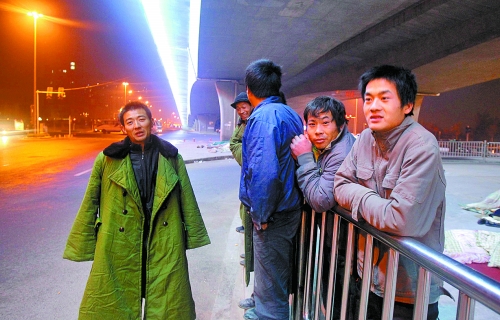 冬夜里，農(nóng)民工在橋下等著干活兒。