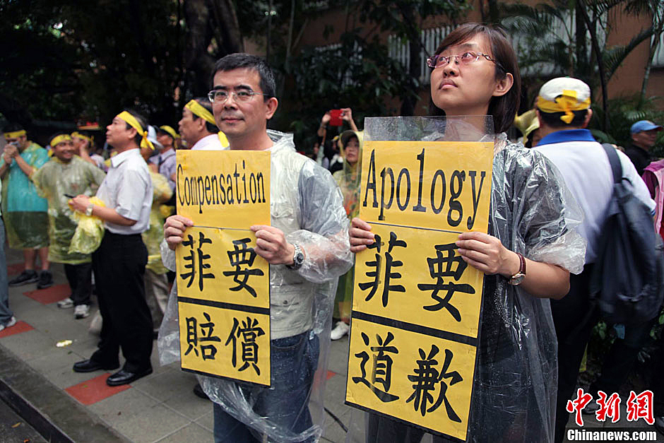　圖為當(dāng)天下午，當(dāng)臺(tái)灣數(shù)百漁民在馬尼拉經(jīng)濟(jì)文化辦事處前抗議時(shí)，有兩名年輕人手持標(biāo)語，在路邊聲援。中新