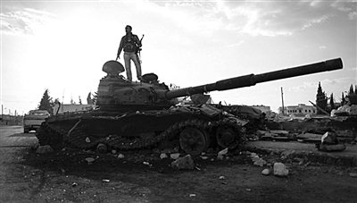 9月8日，敘利亞Zabadani，一名敘利亞反對派武裝人員站在廢棄的政府軍坦克上。