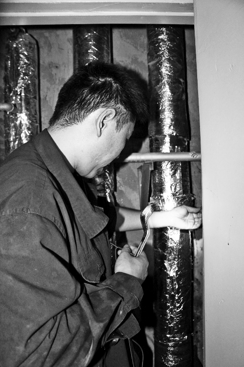 苗師傅一邊進(jìn)行維修，一邊用耳機(jī)接聽市民的電話。