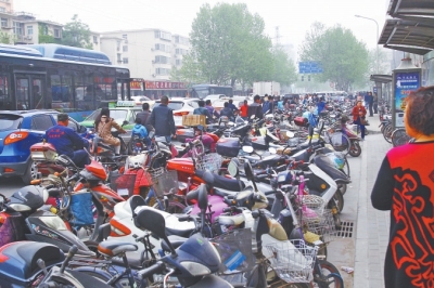 省人民醫(yī)院北門(mén)，路邊的公交站牌處停滿(mǎn)非機(jī)動(dòng)車(chē)，上、下客只能在快車(chē)道上。