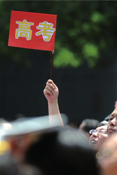 6月7日，在東直門考點(diǎn)外，一名家長(zhǎng)手舉高考的小旗子迎接孩子。資料圖片本報(bào)記者王苡萱攝