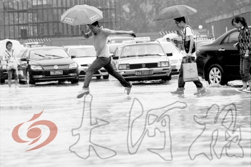 鄭州經(jīng)三路與北環(huán)交叉口處，積水較深，行人們不得不“練輕功”。 記者 白周峰 攝影