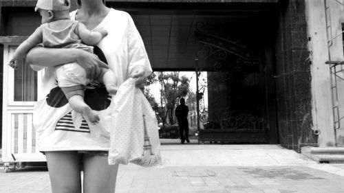 抱著孩子出售人奶的女子。