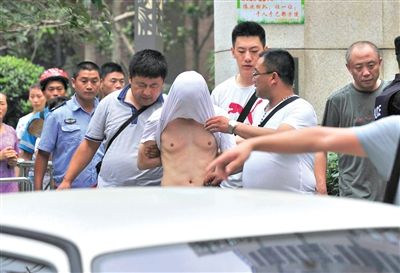 昨日，成都警方抓捕時(shí)與毒犯發(fā)生槍戰(zhàn)。一名男犯罪嫌疑人被警方押出。