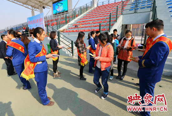 活動(dòng)現(xiàn)場(chǎng)工作人員給同學(xué)們發(fā)放宣傳冊(cè)、環(huán)保袋。