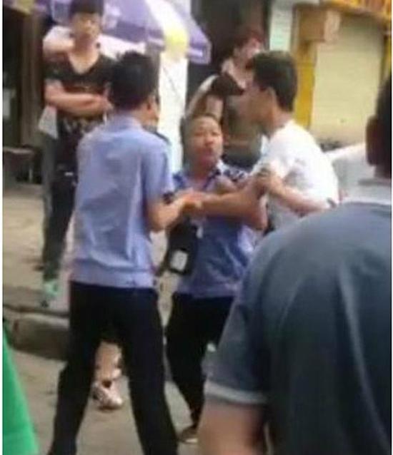 付某（右）與城管執(zhí)法人員廝打在一起。