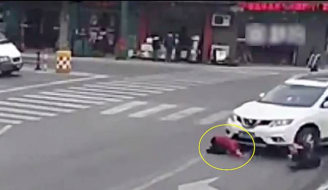 圖為小姑娘被卷進(jìn)車輪下瞬間。